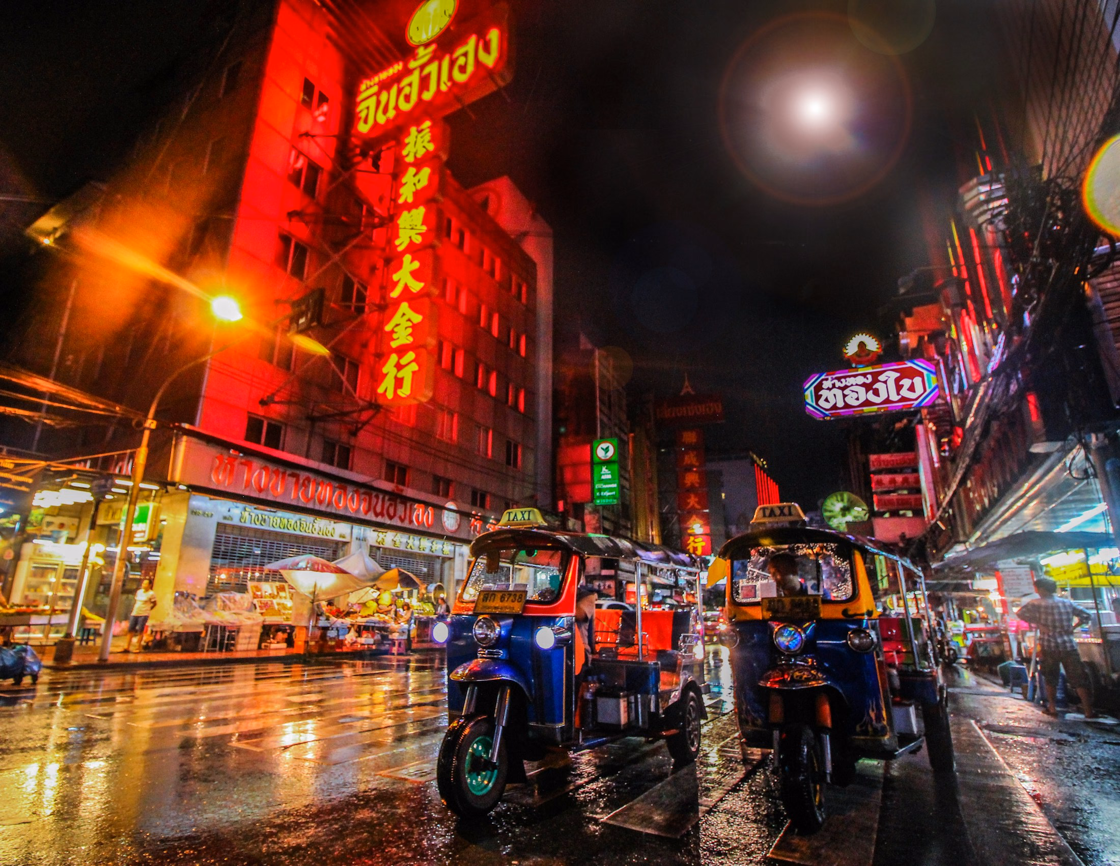 Tuk-tuks and illuminated Bangkok street life at night