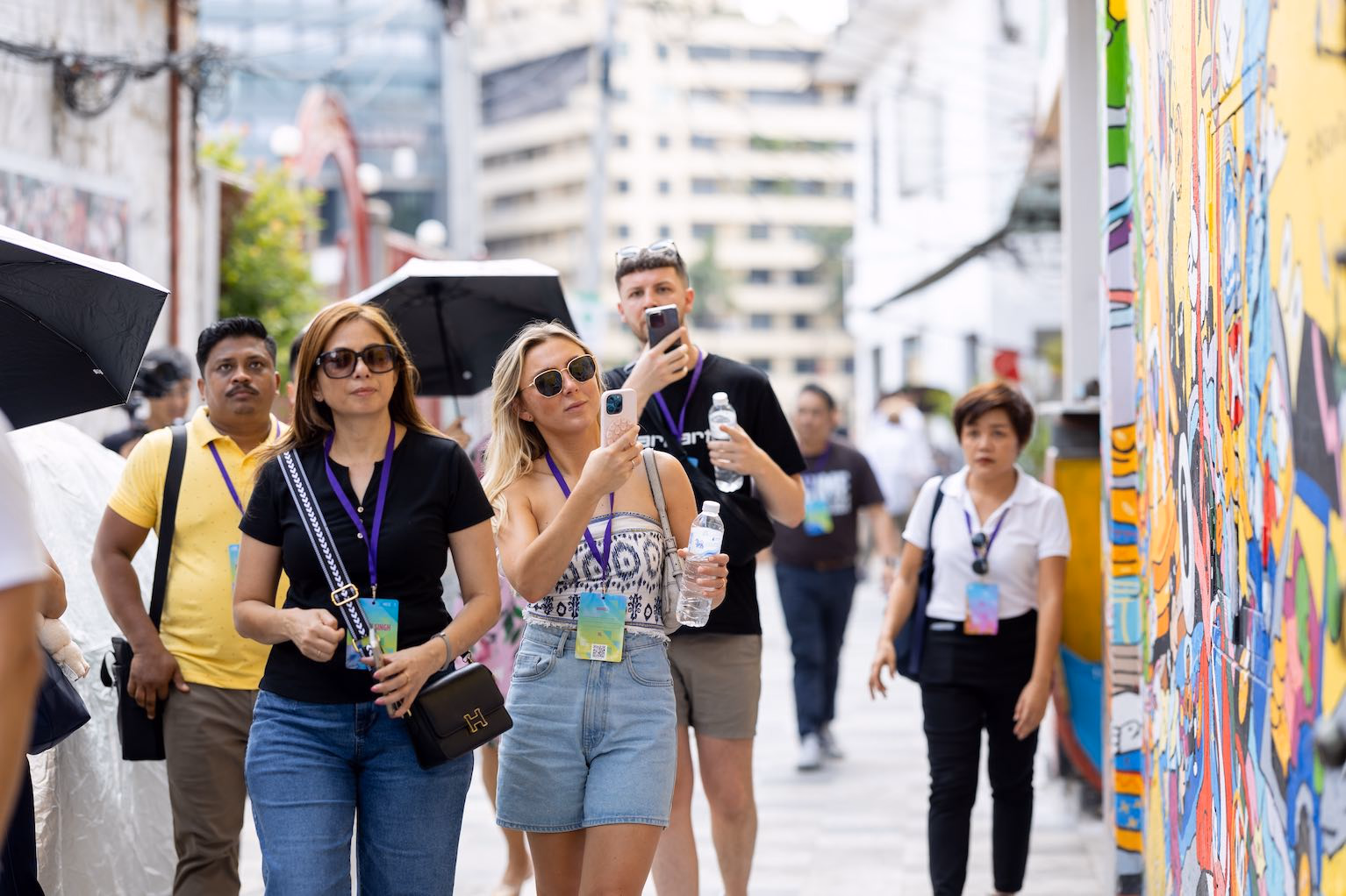 Guests exploring a colourful street-art lane together in Bangkok