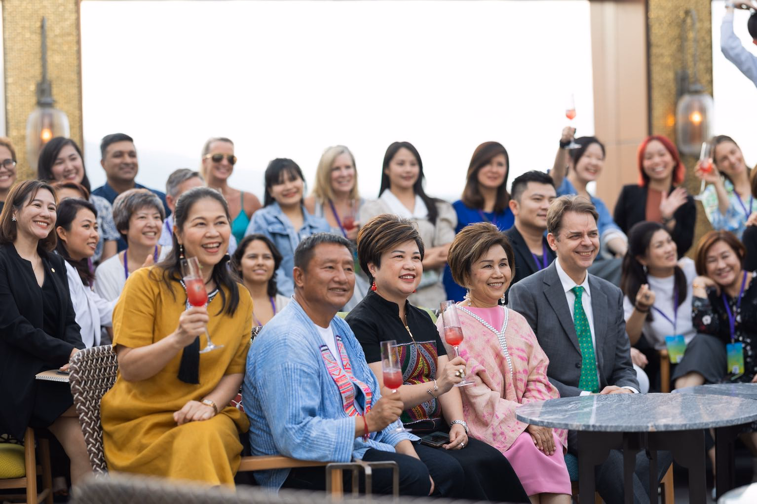 A group of guests smiling together during an outdoor reception in Thailand