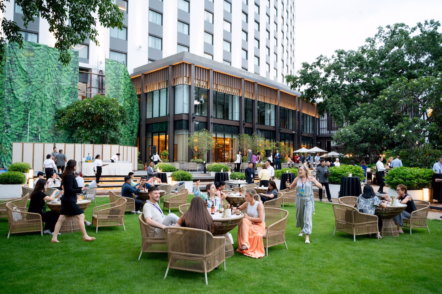 Guests connecting at an outdoor hotel garden reception in Thailand