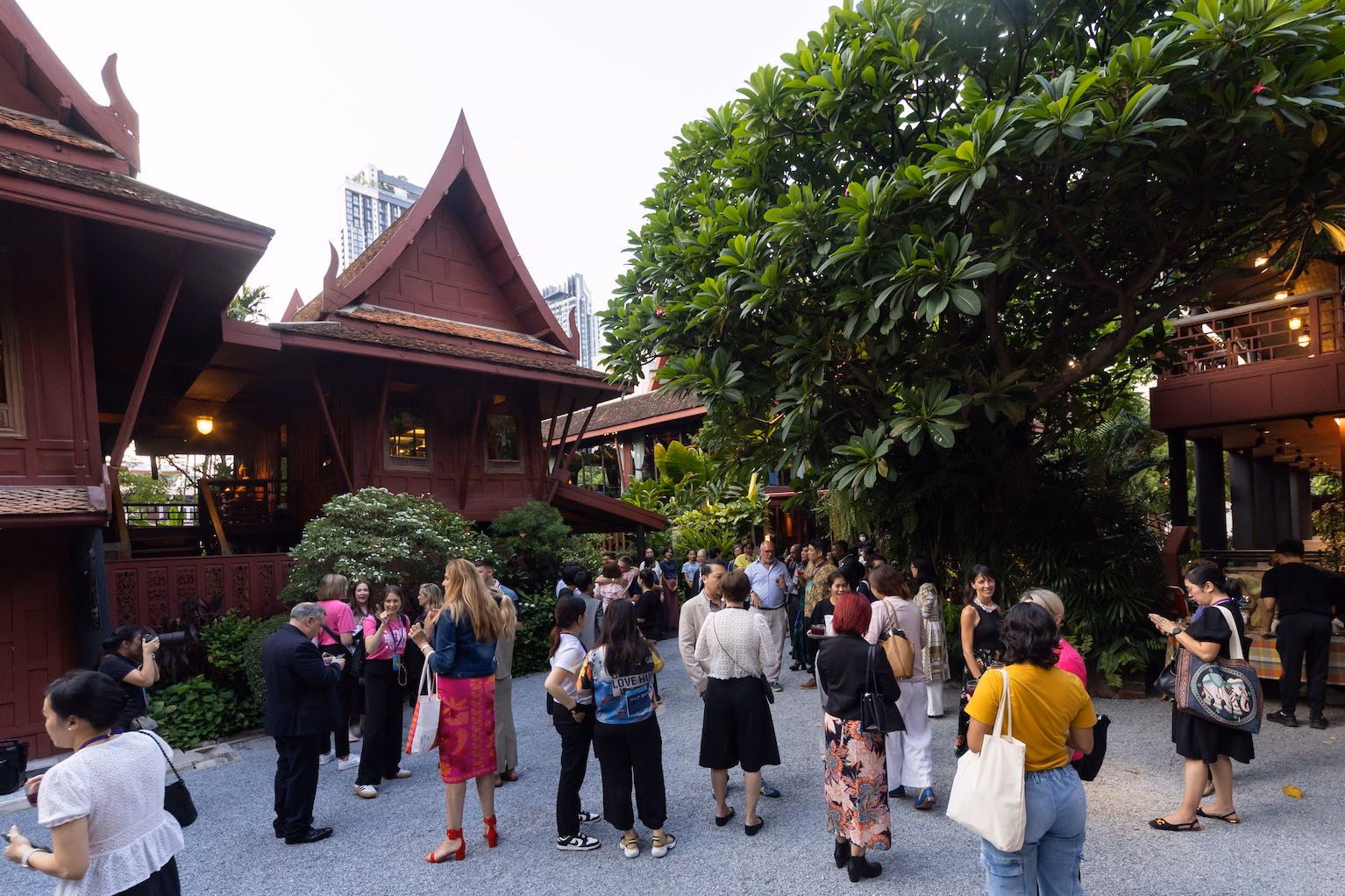 International guests gathering in the courtyard of a traditional Thai house